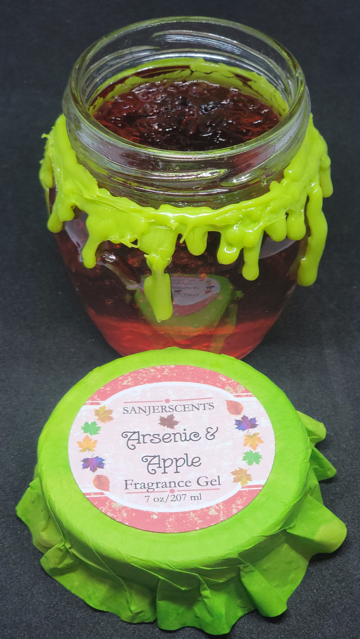 7 oz glass honeypot jar with red Arsenic & Apple fragrance gel. Metal screw top lid with lime green cover.