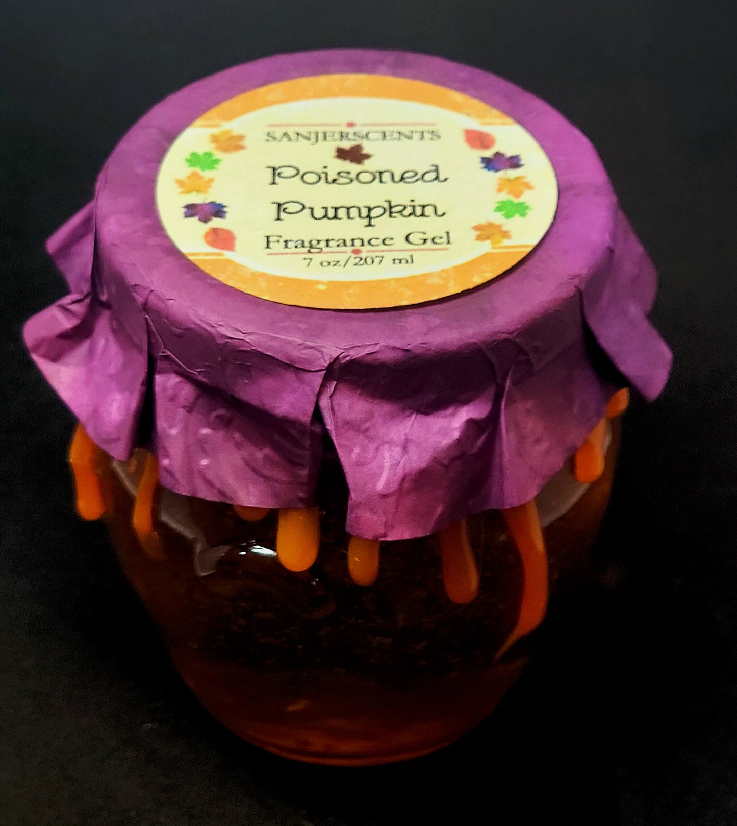 7 oz glass honeypot jar with orange Poisoned Pumpkin fragrance gel. Metal screw top lid with purple cover