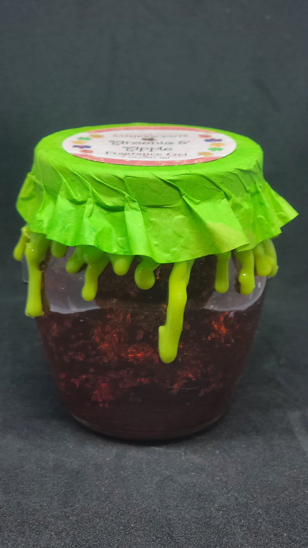 7 oz glass honeypot jar with red Arsenic & Apple fragrance gel.  Metal screw top lid with lime green cover